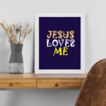 Infidu Jesus Loves Me Bible Wall Art with deep purple background and yellow decorative lettering Wall Art displayed on the table in a white frame