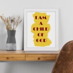 Infidu I Am A Child Of God Bible Wall Art with yellow shape and red text on a white background Wall Art displayed on the table in a white frame