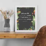 Psalm 50:15 Bible Verse Wall Art with white text, tropical leaves, and black background. Wall Art displayed on the table in a white frame