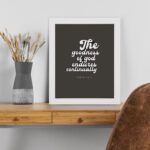 The Goodness of God Endures Continually Psalm 52:1 Christian wall art with white text on a dark gray background. Wall Art displayed on the table in white frame