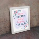 Christian wall art with Isaiah 54:13, featuring 'All Your Children Shall Be Taught By The Lord' in pastel watercolor with floral elements. Wall Art displayed on the wall in a white frame