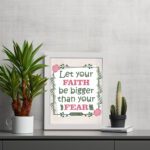 Infidu Let Your Faith Be Bigger Than Your Fear Hebrews 13:6 Christian wall art with floral border on light beige background. Wall Art displayed on the table in a white frame