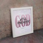 God Will Provide Philippians 4:19 Christian wall art with bold pink 'God' and handwritten 'Will Provide' on a light gray background. Wall Art displayed on the wall in a white frame