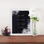 Be Still and Know That I Am God Psalm 46:10 Christian wall art with handwritten text on a navy blue background. wall art displayed on the wall in a white frame