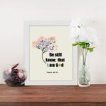 Be Still and Know That I Am God Psalm 46:10 Bible verse wall art with tree graphic, black and green text on a white background. displayed on the table in a white frame