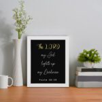 Psalm 18:28 Bible verse wall art with The LORD in yellow on a black background. Christian decor by Infidu. Wall Art on the table in a white frame