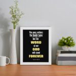 Infidu The Grass Withers The Flower Fades But The Word Of Our God Will Stand Forever Isaiah 40:8 Bible Wall Art and white frame on the table