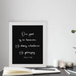 Bible verse wall art with Psalm 115:3 in white text on a black background. Simple and centered design for a bold, modern look. displayed on the table in a white frame