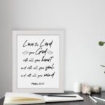 Matthew 22:37 Bible wall art with black text on a white background, featuring Love the Lord your God in cursive letters. displayed on the table in a white frame