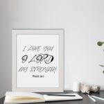 I LOVE YOU O LORD MY STRENGTH black handwritten text on a light background with Psalm 18:1 - Christian wall art for home decor. displayed on the table in a white frame