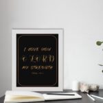 I LOVE YOU O LORD MY STRENGTH gold text on a black background, framed in gold and black - Christian wall art for home decor displayed on the table in a white frame