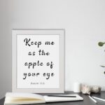 Keep Me As The Apple Of Your Eye Psalm 17:8 black text in cursive on a white background, framed in black displayed on the table in a white frame- Christian wall art