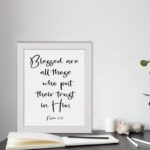 Blessed Are All Those Who Put Their Trust In Him Psalm 2:12 black cursive text on white background - Christian wall art displayed on the table in a white frame