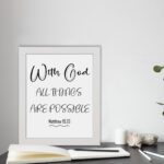 With God All Things Are Possible Matthew 19:26 black text on white background Christian wall art hung in the table in a white frame