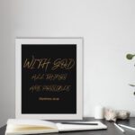 With God, All Things Are Possible Matthew 19:26 gold script on black background Christian wall art displayed on the table in a white frame