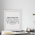 Infidu wall art featuring the text Rejoice Always Pray Without Ceasing. Give Thanks in All Circumstances with floral accents. displayed on the table in a white frame