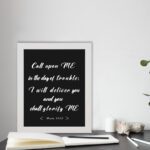 Infidu Call Upon Me In The Day Of Trouble Psalm 50:15 Bible Wall Art with bold white text on a black background. Wall Art displayed on the table in a white frame