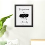 Infidu The Goodness Of God Endures Continually Psalm 52:1 Bible Wall Art with black text and brushstroke design on white background. Wall Art hung on the floor in a black frame