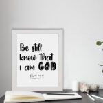 Be Still and Know That I Am God Psalm 46:10 Bible Verse Wall Art with black text on a white background Wall Art displayed on the table in a white frame