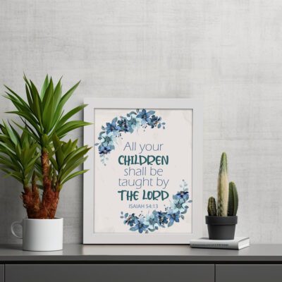 Christian wall art of Isaiah 54:13 with blue text surrounded by a wreath of blue flowers and green leaves on a cream background. Wall Art displayed on the table in a white frame