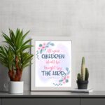 Christian wall art with Isaiah 54:13, featuring 'All Your Children Shall Be Taught By The Lord' in pastel watercolor with floral elements. Wall Art displayed on the table in a white frame