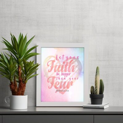 Let Your Faith Be Bigger Than Your Fear Christian wall art with pink and red script font and pastel watercolor background. Wall Art displayed on the table in a white frame