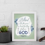 Infidu Matthew 5:8 Christian wall art with silver and dark blue text on a pale green background, featuring 'GOD' in a white oval and blue floral designs. Wall Art displayed on the table in a white frame