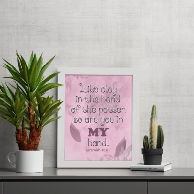 Infidu Jeremiah 18:6 Christian wall art with dark brown cursive text and bold 'MY' in brownish-purple, on a light pink background with leaf patterns. Wall Art displayed on the table in a white frame