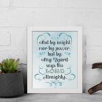 Zechariah 4:6 Bible verse wall art with light blue and white text, decorative flourishes, and a light blue gradient background. Inspiring Christian home decor. Wall Art on the displayed wall in a white frame