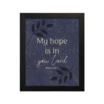 Purple-blue background with black leaf design, white text My Hope Is In You Lord Psalm 39:7 Bible Verse Wall Art black frame hung on the wall.