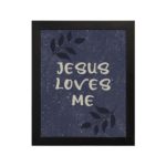 Purple-blue background with black leaf design, white text Jesus Loves Me Bible Verse Wall Art black frame hung on the wall.