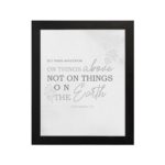 Gray background with leaf design, black and gray text 'Set Your Affection On Things Above Colossians 3:2 Bible Verse Wall Art and black frame hung on the wall.