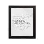 Gray background with leaf design, black and gray text 'Because Your Love Is Better Than Life Psalm 63:3 Bible Verse Wall Art and black frame hung on the wall.