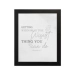 Christian wall art featuring Proverbs 4:7, Getting Wisdom Is The Wisest Thing You Can Do, on a gray background with gray leaf design and black and gray font black frame hung on the wall.