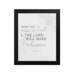 Christian wall art featuring Isaiah 60:22 Bible verse on a gray background with gray leaf design and black and gray font black frame hung on the wall.