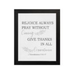 Christian wall art featuring 1 Thessalonians 5:16-17 Bible verse on a gray background with gray leaf design and black and gray font black frame hung on the wall