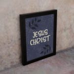 Christian wall art with purple-blue background, black leaf design, and white text Infidu Jesus Christ Bible Verse Wall Art black frame on the wall