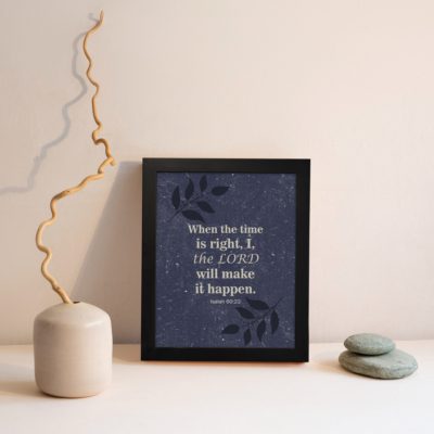 Christian wall art with Isaiah 60:22 verse on a purple-blue background with a leaf design and black frame displayed on the wall