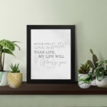 Gray background with leaf design, black and gray text 'Because Your Love Is Better Than Life Psalm 63:3 Bible Verse Wall Art and black frame on the table.