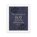 Purple-blue background with black leaf design, white text 'The Goodness Of God Endures Continually Psalm 52:1 Bible Verse Wall Art white frame hung on the wall.