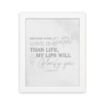 Gray background with leaf design, black and gray text 'Because Your Love Is Better Than Life Psalm 63:3 Bible Verse Wall Art and white frame hung on the wall.