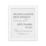 Christian wall art featuring 1 Thessalonians 5:16-17 Bible verse on a gray background with gray leaf design and black and gray font white frame hung on the wall