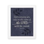 Christian wall art with purple-blue background, black leaf design, and white text And Everyone Who Calls On The Name Of The Lord Will Be Saved Acts 2:21 Bible Verse Wall Art white frame hung on the wall