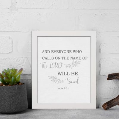 Gray background with leaf design, black and gray text 'And Everyone Who Calls On The Name Of The Lord Will Be Saved Acts 2:21 Bible Verse Wall Art white frame displayed on the wall.