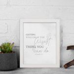 Christian wall art featuring Proverbs 4:7, Getting Wisdom Is The Wisest Thing You Can Do, on a gray background with gray leaf design and black and gray font black frame displayed on the wall.