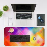 Infidu Geometric Patterns Desk Pad with overlapping transparent diamond shapes in multi-colored gradients. Desk Mat with an Apple Laptop