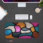 Infidu Artistic Desk Mat with organic, curving multicolored shapes in pink, light blue, yellow, gray, and white. Desk Pad with Design Kept on a computer table