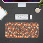 Desk pad with an abstract geometric pattern in blue, orange, and white, featuring triangles and various shapes. Design Kept on a computer table