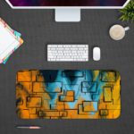 Infidu Artistic Desk Mat with an abstract geometric pattern in yellow, orange, and blue, covering the entire surface. Desk Pad with Design Kept on a computer table