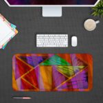 Infidu Artistic Animated Desk Pad with overlapping triangular and rectangular shapes in purple, red, green, orange, and yellow. Desk Pad with Design Kept on a computer table